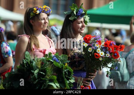 (190622) -- RIGA, 22. Juni 2019 -- Frauen, die Blumenkronen tragen, werden während des Midsummer Festivals Ligo Market in Riga, Lettland, am 21. Juni 2019 gesehen. Am Freitag wurde hier das jährliche Mittsommerfest Ligo Market eröffnet, bei dem Bauern und Handwerker aus ganz Lettland Spezialitäten wie ländliches Brot, Käse, traditionellen Tee, Honig, handgemachte Kuchen und Kapillen verkaufen. ) LETTLAND-RIGA-MIDSUMMER FESTIVAL LIGO MARKET EDIJSXPALENS PUBLICATIONXNOTXINXCHN Stockfoto