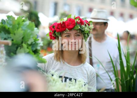 (190622) -- RIGA, 22. Juni 2019 -- Eine Frau, die eine Blumenkrone trägt, wird während des Midsummer Festival Ligo Market in Riga, Lettland, am 21. Juni 2019 gesehen. Am Freitag wurde hier das jährliche Mittsommerfest Ligo Market eröffnet, bei dem Bauern und Handwerker aus ganz Lettland Spezialitäten wie ländliches Brot, Käse, traditionellen Tee, Honig, handgemachte Kuchen und Kapillen verkaufen. ) LETTLAND-RIGA-MIDSUMMER FESTIVAL LIGO MARKET EDIJSXPALENS PUBLICATIONXNOTXINXCHN Stockfoto