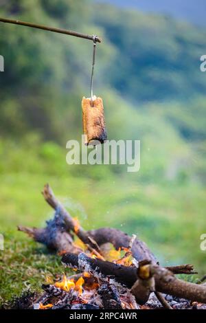Brot toasten über Lagerfeuer, Nusa Penida, Bali, Indonesien Stockfoto