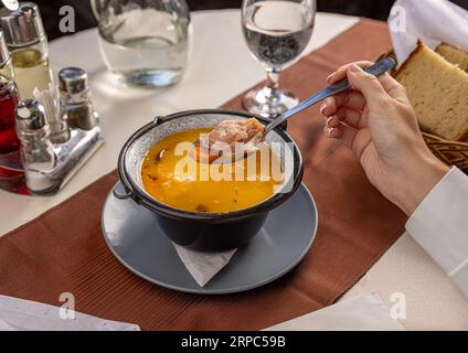 Bohnensuppe mit geräuchertem Schweinefleisch und Gemüse auf dem Restauranttisch Stockfoto