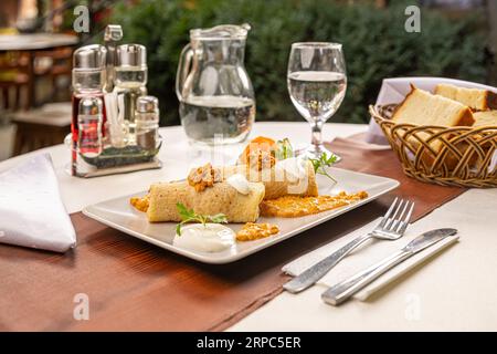 Herzhafte Pfannkuchenbrötchen, gefüllt mit gemahlenem Fleisch, serviert auf dem Restauranttisch Stockfoto