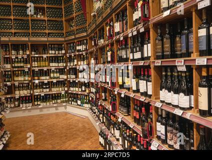 Rack mit verschiedenen Flaschen Wein in Regalen in einem Weinladen. Kopenhagen, Dänemark - 2. September 2023. Stockfoto