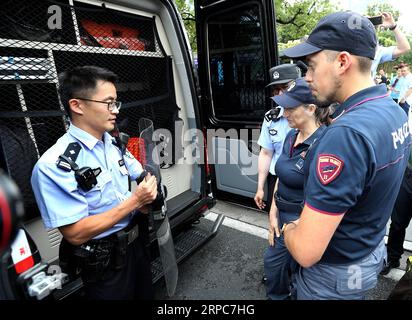 (190626) -- SHANGHAI, 26. Juni 2019 -- Ein chinesischer Polizist erklärt den italienischen Polizeibeamten im ostchinesischen Shanghai Polizeiausrüstung, 26. Juni 2019. Italienische Polizeibeamte begannen am Montag, mit ihren lokalen Kollegen in China touristische Orte zu patrouillieren, nachdem eine Eröffnungszeremonie in Peking stattgefunden hatte. Die gemeinsame Patrouille, die dritte solche Übung zwischen der chinesischen und der italienischen Polizei in China, wird bis zum 5. Juli in vier Städten dauern: Peking, Shanghai, Chongqing und Guangzhou. ) CHINA-SHANGHAI-ITALIEN-POLIZEI-GEMEINSAME PATROUILLE (CN) FANXJUN PUBLICATIONXNOTXINXCHN Stockfoto