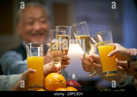 Ein älterer asiatischer Mann, der während einer Familienfeier anspricht, glücklich und lächelnd Stockfoto