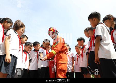 (190627) -- BINZHOU, 27. Juni 2019 -- Ein Feuerwehrmann lehrt Schüler, einen Feuerlöscher an der Grundschule Nr. 1 des Boxing County in Binzhou, ostchinesische Provinz Shandong, zu benutzen, 27. Juni 2019. In ganz China werden Sicherheitsschulungen durchgeführt, um die Schüler auf Sicherheit für einen sicheren Sommerurlaub aufmerksam zu machen. ) CHINA-SAFETY EDUCATION-SUMMER HOLIDAY (CN) CHENXBIN PUBLICATIONXNOTXINXCHN Stockfoto