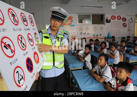 (190627) - BINZHOU, 27. Juni 2019 - Ein Polizeibeamter lehrt Schüler, Verkehrszeichen an der Grundschule Nr. 1 des Boxing County in Binzhou, ostchinesische Provinz Shandong, zu erkennen, 27. Juni 2019. In ganz China werden Sicherheitsschulungen durchgeführt, um die Schüler auf Sicherheit für einen sicheren Sommerurlaub aufmerksam zu machen. ) CHINA-SAFETY EDUCATION-SUMMER HOLIDAY (CN) CHENXBIN PUBLICATIONXNOTXINXCHN Stockfoto