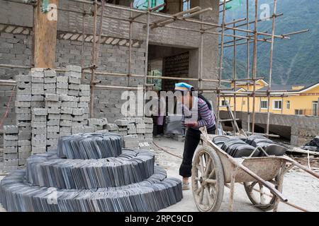 (190628) -- KUNMING, 28. Juni 2019 -- Menschen arbeiten an einem Neuansiedlungsort für Menschen der ethnischen Gruppe Lisu in der Stadt Daxingdi, Autonome Präfektur Lisu in Nujiang, Provinz Yunnan im Südwesten Chinas, 26. Juni 2019. Dank der Politik der lokalen Regierung zur Armutsbekämpfung wurden die Lisu-Menschen in eine neue Gemeinschaft aus unwirtlichen Berggebieten verlagert. Zhiguo-Minderheiten sind besondere Mitglieder der 56 ethnischen Gruppen Chinas. Der Begriff Zhiguo bezieht sich auf Minderheitengruppen, die vor der Modernisierung in relativer Isolation gelebt und die mit der feudalen Monarchie verbundene Übergangszeit übersprungen hatten. Yunnan ist es Stockfoto