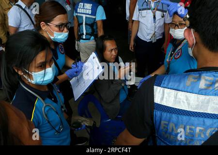 (190703) -- PASIG, 3. Juli 2019 -- medizinische Ersthelfer helfen einer Frau, die sich aufgrund einer vermuteten Lebensmittelvergiftung in Pasig City, Philippinen, am 3. Juli 2019 krank fühlt. Mindestens 260 Menschen erkrankten bei der Feier zum 90. Geburtstag von Imelda Marcos, Ehefrau des ehemaligen Präsidenten Ferdinand Marcos, am Mittwoch in der Stadt Pasig in Metro Manila, nachdem sie ein kontaminiertes Mittagessen gegessen hatten, sagten Polizei- und Gesundheitsbeamte. PHILIPPINEN-PASIG-VERDACHTSVERGIFTUNG ROUELLExUMALI PUBLICATIONxNOTxINxCHN Stockfoto