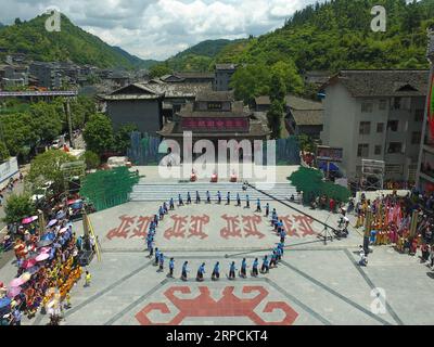 (190708) -- PEKING, 8. Juli 2019 -- Luftaufnahme aufgenommen am 6. Juni 2019 zeigt Menschen der ethnischen Gruppe Tujia, die tanzten, um den Sheba-Tag in der Stadt Xichehe im Bezirk Longshan in der zentralchinesischen Provinz Hunan zu feiern. Die Provinz Hunan liegt in Zentralchina und ist für ihre abwechslungsreiche Topographie bekannt. Er grenzt im Norden an den Dongting Lake, und die Ost-, Süd- und Westseite der Provinz sind von Bergen umgeben, mit den Wuling- und Xuefeng-Bergen im Westen, dem Nanling-Berg im Süden, den Luoxiao- und den Mufu-Bergen im Osten. Die Flüsse Xiangjiang, Zijiang, Yuanjiang und Lishui fließen zusammen Stockfoto