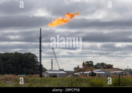 Kokomo - 30. August 2023: Gasflamme auf einer Baustelle. Eine Gasflamme ist eine Verbrennungsvorrichtung, die zum Abbrennen überschüssiger entzündlicher Gasdämpfe verwendet wird. Stockfoto