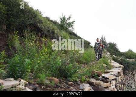 (190713) -- ZHANGZI, 13. Juli 2019 -- Waldranger Herr He Xiaohong (Front) und Lin Zhongkui patrouillieren auf dem Berg Fajiu, 25 km westlich von Zhangzi County, nordchinesische Provinz Shanxi, 12. Juli 2019. Auf dem Mount Fajiu gibt es eine Waldwaldstation, wo die Waldbedeckung fast 90 Prozent beträgt. Herr He Xiaohong ist seit seinem 19. Lebensjahr seit 34 Jahren im Forstschutz tätig. Zusammen mit seinen Arbeitskollegen muss er das ganze Jahr über zweimal vom frühen Morgen bis zum Abend patrouillieren, um sicherzustellen, dass sich die Wälder in einer guten Lage befinden. Unter ihrem Schutz gab es kein wildes Feuer Stockfoto