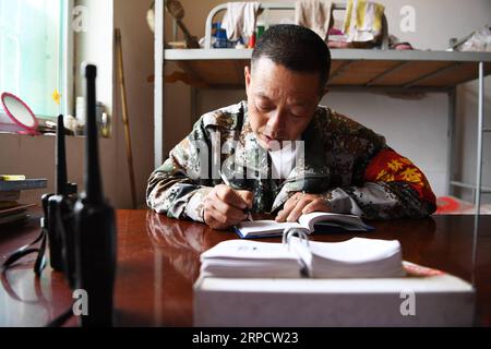 (190713) -- ZHANGZI, 13. Juli 2019 -- Waldranger He Xiaohong nimmt Patrouillennotizen an seiner Waldpatrouillenstation auf dem Mount Fajiu, 25 km westlich von Zhangzi County, nordchinesische Provinz Shanxi, am 12. Juli 2019. Auf dem Mount Fajiu gibt es eine Waldwaldstation, wo die Waldbedeckung fast 90 Prozent beträgt. Herr He Xiaohong ist seit seinem 19. Lebensjahr seit 34 Jahren im Forstschutz tätig. Zusammen mit seinen Arbeitskollegen muss er das ganze Jahr über zweimal vom frühen Morgen bis zum Abend patrouillieren, um sicherzustellen, dass sich die Wälder in einer guten Lage befinden. Unter ihrem Schutz gab es nichts Stockfoto