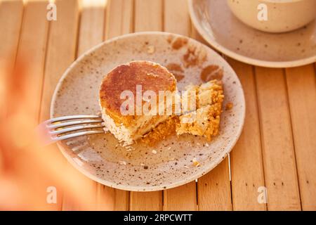 Veganes gesundes Karottendessert unter harten Schatten mit einer Tasse Cappuccino. Kein Backen und kein Zucker glutenfreier Kuchen. Stockfoto