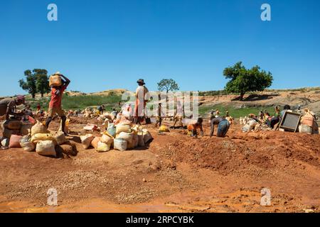 Ihosy, Ilakaka, Madagaskar - 20. November 2022: Die Einheimischen suchen nach Edelsteinen und Pfannen nach Gold in einem Fluss. Die Stadt ist ein wichtiges Zentrum für Saphirprodukte Stockfoto