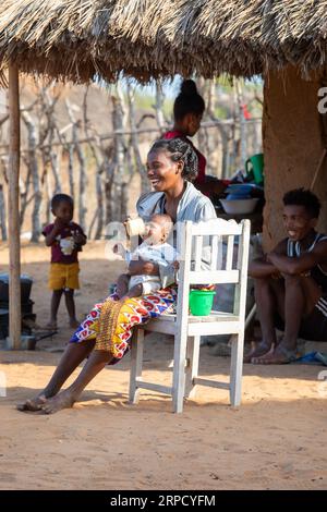 Kivalo, Madagaskar - 4. November. 2022: Eine madagassische Frau im Dorf Kivalo nimmt sich einen Moment Zeit, um ihr Baby an einem sonnigen November vor ihrer Hütte zu füttern Stockfoto