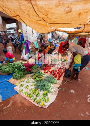 Mandoto, Madagaskar - 9. November 2022: Straßenmarkt in der Stadt Mandoto, mit Händlern und einfachen Menschen, die einkaufen und Kontakte knüpfen. Die Frau sitzt auf dem Boden Stockfoto