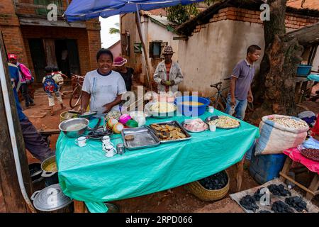 Mandoto, Madagaskar - 9. November 2022: Straßenmarkt in der Stadt Mandoto, mit Händlern und einfachen Menschen, die einkaufen und Kontakte knüpfen. Frau verkauft lokale s Stockfoto