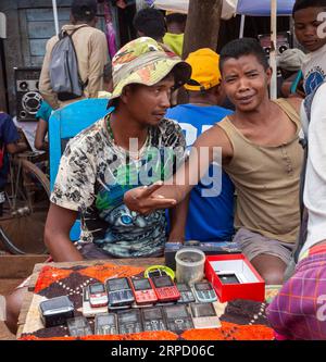 Mandoto, Madagaskar - 2. November 2022: Madagassischer Mann verkauft altmodische Mobiltelefone auf der Straße von Mandoto. Stockfoto