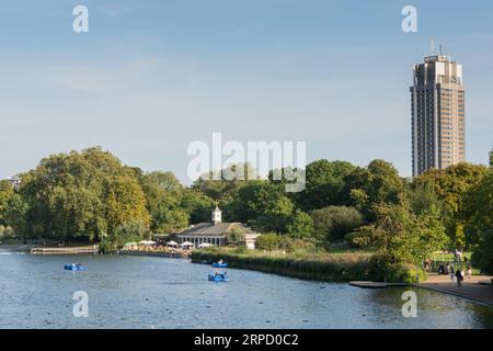 Tretboote auf der Serpentine im Londoner Hyde Park mit dem Park Lane Hilton im Hintergrund Stockfoto