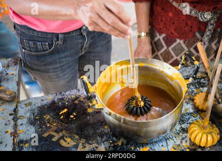 (190717) -- UBON RATCHATHANI (THAILAND), 17. Juli 2019 -- Ein Tourist macht eine Kerzenblume in einem Tempel in Ubon Ratchathani, Thailand, 15. Juli 2019. Das Ubon Ratchathani Candle Festival erinnert an die erste Predigt Buddhas und markiert den Beginn der buddhistischen Fastenzeit. Das Highlight der jährlichen Veranstaltung ist die Parade von riesigen Wagen mit Wachskulpturen in der ganzen Stadt, die jeweils einen lokalen Tempel, einen Bezirk oder eine Institution darstellen. ) THAILAND-UBON RATCHATHANI-CANDLE FESTIVAL ZhangxKeren PUBLICATIONxNOTxINxCHN Stockfoto