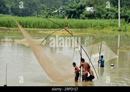 (190718) -- TANGAIL (BANGLADESCH), 18. Juli 2019 (Xinhua) -- Menschen fangen am 18. Juli 2019 in Tangail, Bangladesch, in Überschwemmungsgewässern. Sturzfluten, die durch starke saisonale Regenfälle ausgelöst wurden, betrafen Teile von Bangladesch. (STR/Xinhua) BANGLADESCH-TANGAIL-FLOODPUBLICATIONXNOTXINXCHN Stockfoto