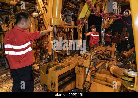 (190719) -- NANCHANG, 19. Juli 2019 -- die Konstrukteure benutzen eine große Stanzmaschine, um die neu gelegten Gleise in der Stadt Nanchang, der ostchinesischen Provinz Jiangxi, zu warten, 19. Juli 2019. Mit mehr als 1.000 Bauunternehmern, die acht Stunden lang arbeiten, hat die Nanchang-Ganzhou-Hochgeschwindigkeitsbahn am Freitag erfolgreich mit dem Nanchang-Verkehrsknotenpunkt verbunden, was bedeutet, dass sie offiziell dem chinesischen Hochgeschwindigkeitsbahnnetz beigetreten ist. Die 415 734 Kilometer lange Hochgeschwindigkeitsbahn Nanchang-Ganzhou mit einer Geschwindigkeit von 350 km/h verbindet die Stadt Nanchang mit der Stadt Ganzhou der Provinz Jiangxi. ) CHINA-JIANGXI-NA Stockfoto