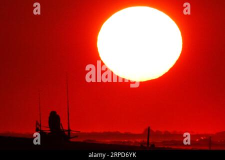 Isle Of Palms, Vereinigte Staaten. September 2023. Ein Fischer stellt seine Stöcke vor dem Sonnenaufgang auf, bevor die Strandmassen ankommen, um den traditionellen letzten Tag der Strandferien am Labor Day, 4. September 2023 auf der Isle of Palms, South Carolina, zu genießen. Quelle: Richard Ellis/Richard Ellis/Alamy Live News Stockfoto