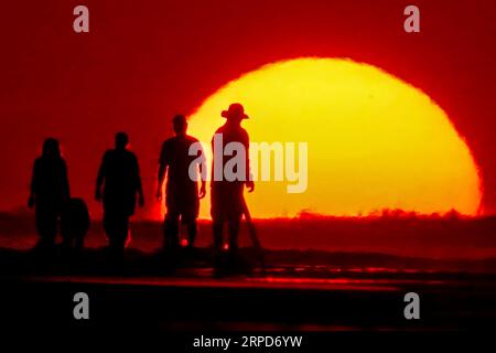 Isle Of Palms, Vereinigte Staaten. September 2023. Strandurlauber, die vom Sonnenaufgang umgeben sind, genießen die Morgenruhe vor dem Ansturm der Menschenmassen am inoffiziellen Ende des Sommers, der vom Labor Day, 4. September 2023 in Isle of Palms, South Carolina, gekennzeichnet ist. Quelle: Richard Ellis/Richard Ellis/Alamy Live News Stockfoto