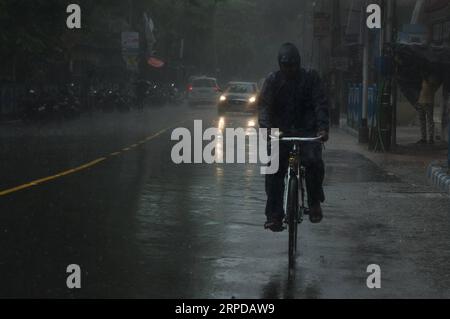 (190728) -- KOLKATA, 28. Juli 2019 (Xinhua) -- Ein Radfahrer reitet bei starkem Regen in Kalkata, Indien, am 28. Juli 2019. Indien hat derzeit seine Monsunsaison, die bis September dauern wird. (Xinhua/Tumpa MONDAL) INDIEN-KOLKATA-MONSUN REGEN PUBLICATIONxNOTxINxCHN Stockfoto