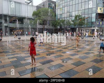 (190730) -- PEKING, 30. Juli 2019 -- mit dem Handy aufgenommenes Foto zeigt Kinder, die im Sanlitun im Bezirk Chaoyang in Peking, der Hauptstadt Chinas, mit Wasser spielen, 28. Juli 2019. ) (BeijingCandid)CHINA-BEIJING-SUMMER (CN) JuxHuanzong PUBLICATIONxNOTxINxCHN Stockfoto