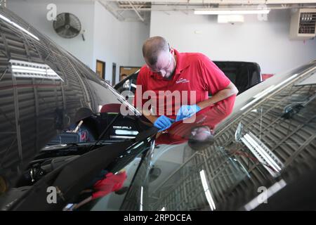 (190731) -- DAYTON, 31. Juli 2019 -- Ein Arbeiter installiert die Windschutzscheibe des Glasherstellers Fuyao an einem Auto in einer Autowerkstatt in Dayton, Ohio, USA, 26. Juli 2019. Als der chinesische führende Automobilglashersteller Fuyao vor fünf Jahren den Standort des ehemaligen General Motors-Werks in Dayton, Ohio, übernahm, jubelte die lokale Gemeinde dem möglichen Aufschwung zu, der die Revitalisierungsbemühungen der Rostgürtelstadt noch verstärken könnte. Im Jahr 2014 erwarb Fuyao ein ehemaliges Werk von General Motors in Moraine, einer Stadt im Bundesstaat Ohio, und verwandelte den Veranstaltungsort, der während der Finanzkrise von 2008 geschlossen wurde, in ein Gebäude Stockfoto