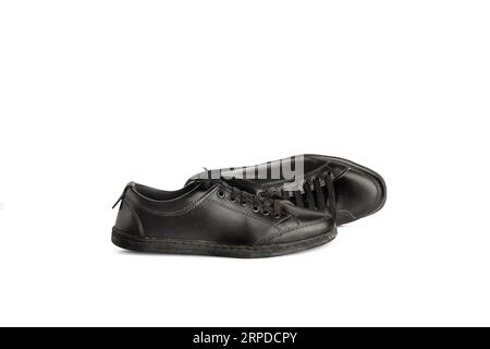 Ein Paar schwarze Ledersneaker auf weißem Hintergrund mit Kopierraum Stockfoto