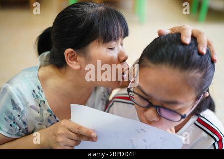 (190731) -- NANCHANG, 31. Juli 2019 -- Liu Xiaoqing unterrichtet einen Schüler an der Luxi County Special Education School im Luxi County von Pingxiang, ostchinesische Provinz Jiangxi, 3. Juli 2019. Als die Luxi County Special Education School 1997 gegründet wurde, bewarb sich Liu Xiaoqing, damals ein normaler Universitätsabsolvent, ohne zu zögern um einen Posten dort. Die Arbeit als Sonderpädagoge war eine Herausforderung, da Lius Schüler viel mehr Aufmerksamkeit benötigen als ihre Kollegen ohne körperliche oder geistige Behinderung. Aber Liu blieb 22 Jahre auf ihrem Posten und half ihren Schülern, sich mit zu verbessern Stockfoto