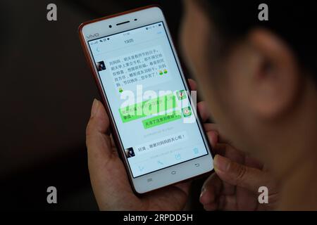 (190731) -- NANCHANG, 31. Juli 2019 -- Liu Xiaoqing zeigt einen WeChat-Dialog mit einem Studenten, der über die Zulassung zum College im Jahr 2018 berichtete, im Luxi County von Pingxiang, ostchinesische Provinz Jiangxi, 3. Juli 2019. Als die Luxi County Special Education School 1997 gegründet wurde, bewarb sich Liu Xiaoqing, damals ein normaler Universitätsabsolvent, ohne zu zögern um einen Posten dort. Die Arbeit als Sonderpädagoge war eine Herausforderung, da Lius Schüler viel mehr Aufmerksamkeit benötigen als ihre Kollegen ohne körperliche oder geistige Behinderung. Aber Liu blieb 22 Jahre lang auf ihrem Posten und half ihren Schülern, sich zu verunsichern Stockfoto