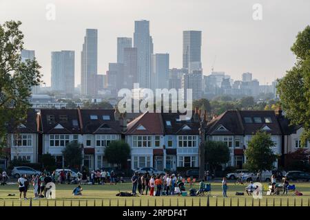 Eine Gemeinschaft von Parknutzern und Vorortwohnungen mit weit entfernten Stadthöhen, die vom Ruskin Park, einem öffentlichen Grünplatz in Lambeth, am 2. September 2023 in London, England, aus gesehen werden. Stockfoto