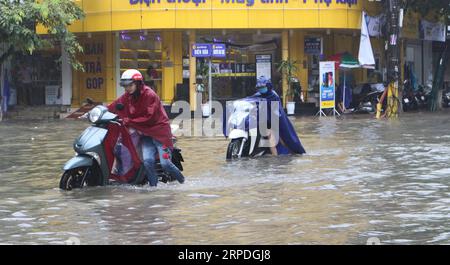 (190803) -- HANOI, 3. August 2019 (Xinhua) -- Anwohner waten am 3. August 2019 nach schweren Regenfällen, die durch den Taifun Wipha in der Provinz Ha Nam in Vietnam verursacht wurden, durch Überschwemmungen. Taifun Wipha, der dritte tropische Sturm, der Vietnam bisher in diesem Jahr getroffen hat, hat eine Person getötet und 15 andere vermisst, berichtete die Vietnam News Agency am Samstag. (Xinhua/VNA) VIETNAM-TYPHOON WIPHA-AFTERMATH PUBLICATIONxNOTxINxCHN Stockfoto