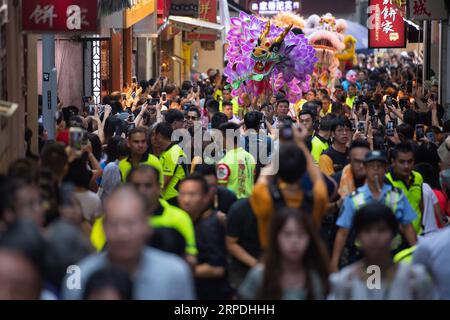 (190805) -- PEKING, 5. August 2019 -- am 4. August 2019 tanzen Menschen auf einer Einkaufsstraße im südchinesischen Macao mit Drachen und Löwen. ) XINHUA FOTOS DES TAGES CheongxKamxKa PUBLICATIONxNOTxINxCHN Stockfoto
