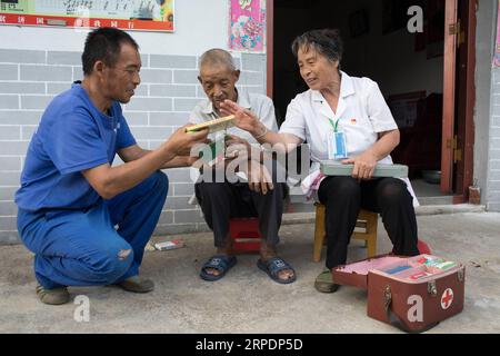 (190809) -- NANCHANG, 9. August 2019 -- Gao Yinshui verteilt Medikamente an ihre Patienten im Dorf Lixin der Stadt Meiling im Bezirk Wanli der Stadt Nanchang, ostchinesische Provinz Jiangxi, 8. August 2019. Fast jeden Tag in den letzten vier Jahrzehnten spaziert die 69-jährige Dorfarzentin Gao Yinshui kilometerlang auf Bergstraßen, um ihre Patienten in neun verschiedenen Dörfern zu sehen. Ende 1970 erlitt Gaos Mutter einen Notfall und hatte das Glück, von einem örtlichen Landarzt gerettet zu werden. Aus diesem Grund gab Gao Yinshui die Gelegenheit auf, Lehrer zu werden und entschied sich, ein Landarzt zu werden. Sie hat jedoch keine medizinische F Stockfoto