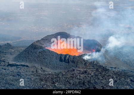 Nahaufnahme des Spritzkegels mit Lava aus Spalten in der Nähe des Litli-Hrútur-Hügels während der Eruption 2023 in der Nähe des Berges Fagradalsfjall, Islands Vulkan A Stockfoto