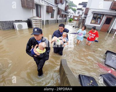 News Bilder des Tages (190810) -- ZHOUSHAN, 10. Aug. 2019 -- Polizisten verlegen die von Überschwemmungen betroffenen Menschen in Putuo, landschaftlich reizvolle Gegend der Stadt Zhoushan, ostchinesische Provinz Zhejiang, 10. Aug. 2019. Taifun Lekima, der neunte des Jahres, landete am Samstag in Wenling City. Rettungs- und Reinigungsarbeiten wurden in allen Teilen der Provinz Zhejiang durchgeführt. (Foto: /Xinhua) CHINA-ZHEJIANG-TAIFUN LEKIMA-RESCUE (CN) ZouxXunyong PUBLICATIONxNOTxINxCHN Stockfoto