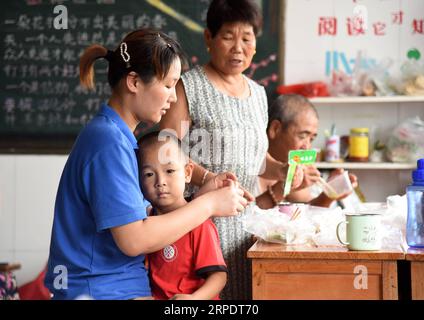 (190811) -- RIZHAO, 11. August 2019 -- Bürger essen am provisorischen Umzugsort in der Experimentellen Grundschule der Entwicklungszone Rizhao in Rizhao, Ostchinesische Provinz Shandong, 11. August 2019. Die Bürger werden in den provisorischen Einrichtungen umgesiedelt, bevor der Taifun Lekima, der neunte des Jahres, in einigen Gebieten der Stadt landete. ) CHINA-SHANDONG-RIZHAO-TYPHOON-LEKIMA (CN) WANGXKAI PUBLICATIONXNOTXINXCHN Stockfoto