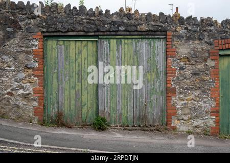 Verwitterte grüne Holzpaneele, doppelte Garagentore Stockfoto