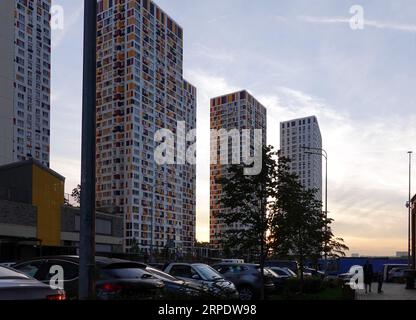 Neue moderne Gebäude mit vielen Fenstern im Schlafbereich der Stadt am Abend bei Sonnenuntergang Stockfoto