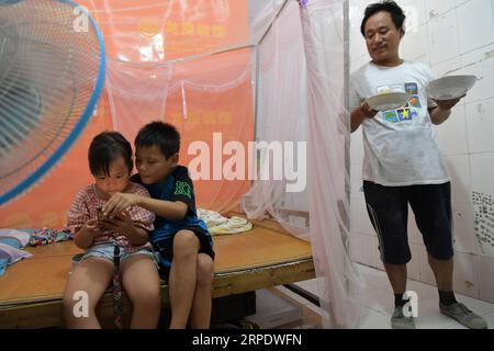 (190813) -- NANCHANG, 13. August 2019 -- Tan Hongbo bringt Geschirr für seine Kinder in ihrem Mietshaus im Bezirk Qingshanhu, Stadt Nanchang, ostchinesische Provinz Jiangxi, 6. August 2019. Tan Hongbo, 39, und seine Frau Wang Yuanzhen, 34, sind Wanderarbeiter in Nanchang. Sie hinterließen ihren Sohn Tan Zheng und ihre Tochter Tan Jinxin bei Großeltern im Duchang County der Stadt Jiujiang. In den Sommerferien kamen die Kinder nach Nanchang, um sich mit ihren Eltern zu vereinigen. Das Paar Tan Hongbo beschloss, ihre Kinder nach Nanchang zu verlegen, um nächstes Jahr als Bildungsabteilung des Bezirks Qingshanhu i zur Schule zu gehen Stockfoto