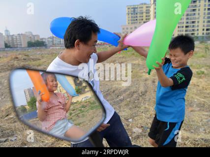 (190813) -- NANCHANG, 13. August 2019 -- Tan Hongbo spielt mit seinen Kindern, nachdem er seine Arbeit in einem städtischen Dorf im Bezirk Qingshanhu, Stadt Nanchang, ostchinesische Provinz Jiangxi, am 12. August 2019 beendet hat. Tan Hongbo, 39, und seine Frau Wang Yuanzhen, 34, sind Wanderarbeiter in Nanchang. Sie hinterließen ihren Sohn Tan Zheng und ihre Tochter Tan Jinxin bei Großeltern im Duchang County der Stadt Jiujiang. In den Sommerferien kamen die Kinder nach Nanchang, um sich mit ihren Eltern zu vereinigen. Das Paar Tan Hongbo beschloss, ihre Kinder nach Nanchang zu verlegen, um nächstes Jahr als Bildungsabteilung von Qing zur Schule zu gehen Stockfoto