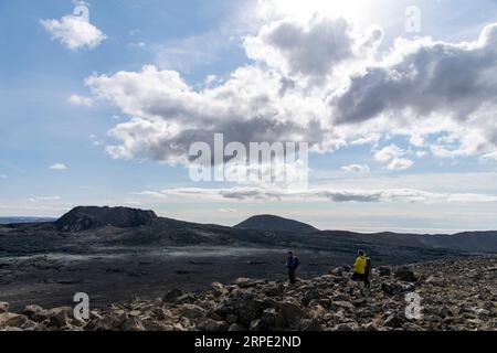 Grindavik, Island-28. Juli 2023; Menschen mit Blick auf Lavafield in der Nähe des Berges Fagradalsfjall mit 2021 Fissurenschlot Geldingadalir Vulkangebiet im Süden Stockfoto