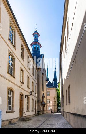 Ville-Haute Luxembourg-25. Mai 2023; Kopfsteinpflasterstraße mit historischen Häusern in der Altstadt und Kirche im Hintergrund Stockfoto