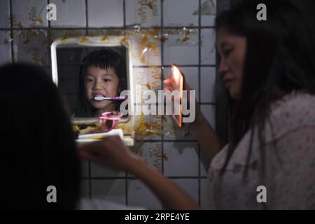 (190818) -- PEKING, 18. August 2019 -- Lu Changli putzt sich die Zähne in Begleitung ihrer Mutter im Schlafsaal einer Kleiderfabrik in Shishi, südöstliche chinesische Provinz Fujian, 5. August 2019. Die sengende Hitze hat Shishi im Südosten Chinas Fujian in diesem Sommer verschlingen lassen und nur wenige laufen auf den normalerweise geschäftigen Straßen. Im Gegensatz dazu sind die Kleiderfabriken, die in der Stadt dicht besiedelt sind, mit Menschen überfüllt, die von ihrer Arbeit überschwemmt wurden, da der Sommer die Hauptsaison für die Herstellung von Kleidungsstücken jedes Jahr ist, und auch ihre Kinder. Der Status Shishis als wichtiger Kleiderhändler Stockfoto