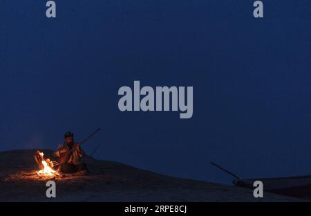 (190821) -- YULI, 21. August 2019 -- Amudun Abudu spielt ein Instrument in Lop nur People Village im Yuli County, nordwestchinesische Autonome Region Xinjiang Uygur, 11. April 2019. Lop nur People Village liegt im Yuli County, wo der Tarim River durch die Wüsten fließt, wobei die Populus euphratica Wälder die schimmernden Wellen reflektieren. Amudun Abudu, ein 61 Jahre alter typischer Dorfbewohner von Lop nur, arbeitet in der lokalen Tourismusbranche. Mit dem Wandel der Zeit haben viele Menschen in Lop nur verschiedene Lebensmöglichkeiten, doch er beharrt auf der Tradition des Fischens in Flüssen und Seen. Er macht nicht nur d Stockfoto