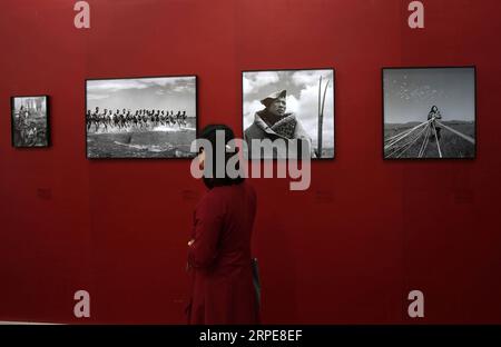 (190821) -- PEKING, 21. August 2019 -- Ein Besucher sieht alte Fotografien auf einer Ausstellung während der 26. Internationalen Buchmesse in Peking, Hauptstadt Chinas, 21. August 2019. Die Buchmesse und die 9. China Digital Publishing Expo begannen am Mittwoch am neuen Veranstaltungsort des China International Exhibition Center. ) CHINA-PEKING-BUCHMESSE (CN) JinxLiangkuai PUBLICATIONxNOTxINxCHN Stockfoto